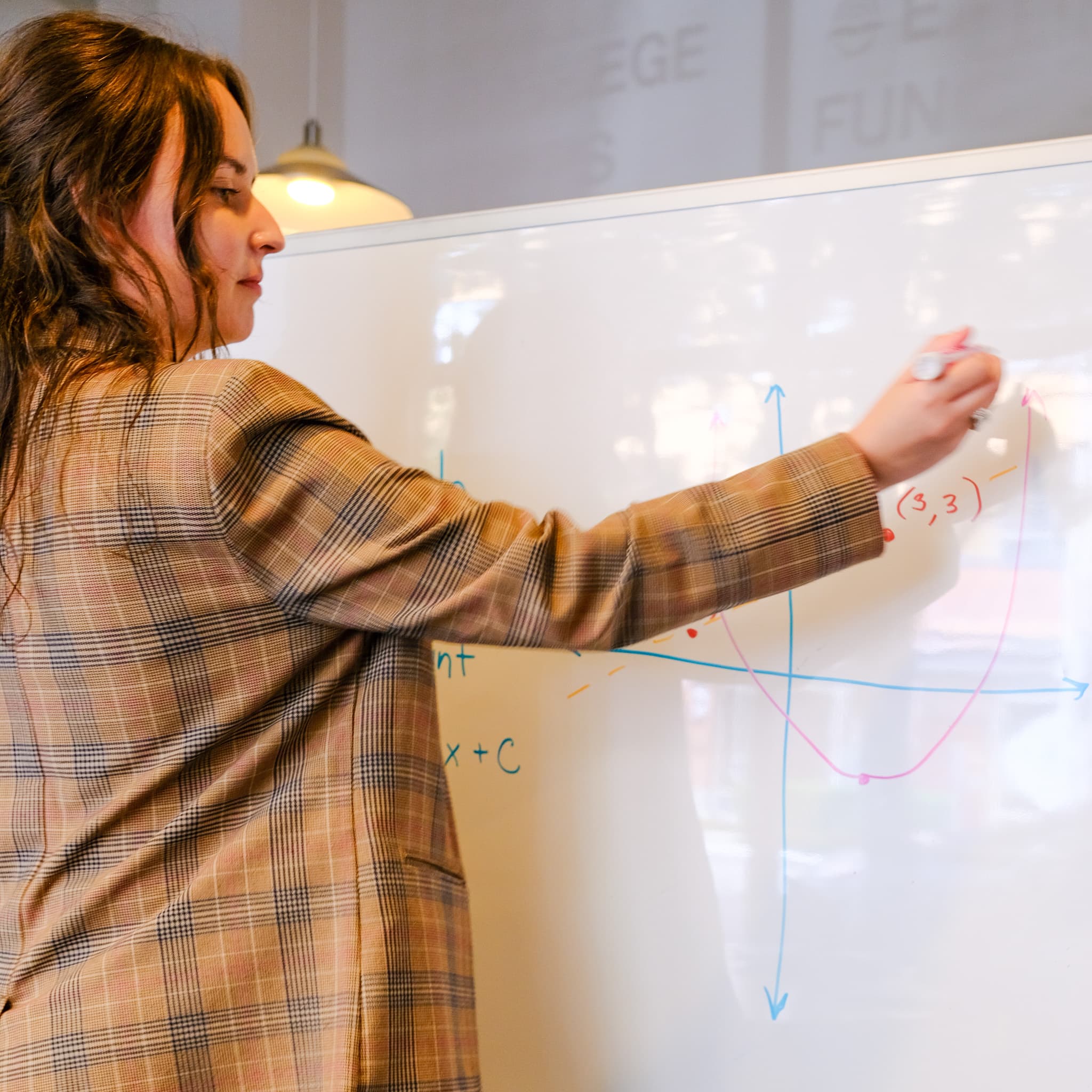 A freelancer working through a problem at a whiteboard